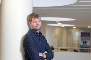 Jyväskylän-yliopiston-väitöskirjatutkija-Antti-Löppönen-vauhditti-ideansa-prototyyppiä-Tuotekehitysrahoituksella-kuvassa-Antti-seisoo-yliopistolla-nojaten-tolppaan