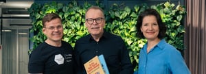 kolme-henkilöä-seisoo-rivissä-ja-hymyilee